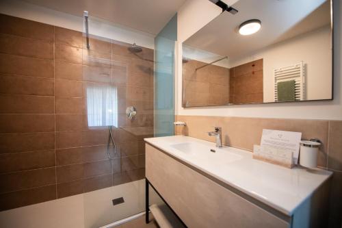 a bathroom with a sink and a shower at Maison Selva - Corte Brunati Villetta Deluxe con piscina e garage in Salò
