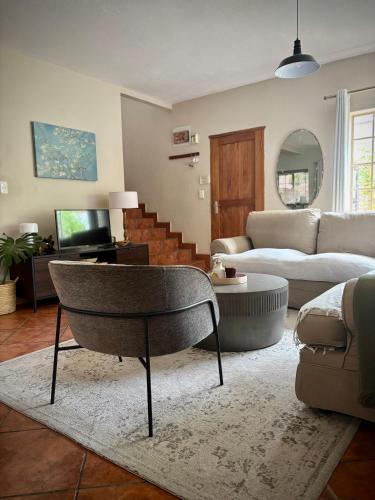 a living room with a couch and a chair at Fig Tree Rock 2-bed, 2-bath villa with garden and parking in Nelspruit
