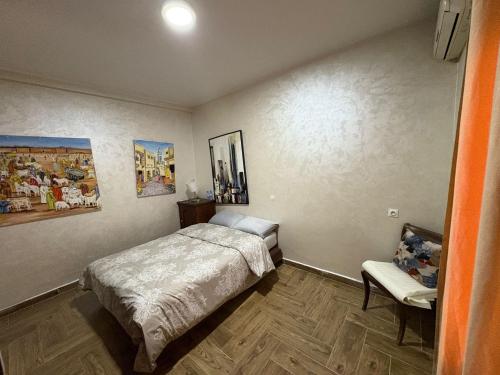 a bedroom with a bed and a chair at Appartement plein centre marrakech p in Marrakesh