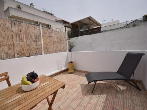 a bowl of fruit on a table and a chair on a balcony at Peaceful Algarve Getaway in Olhão