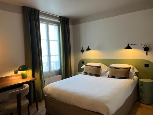a bedroom with a bed and a desk and a window at Monsieur Jules Hôtel Clamart in Clamart
