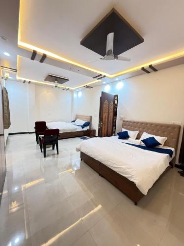 a bedroom with two beds and a table in it at Shree ji palace hotel in Udaipur