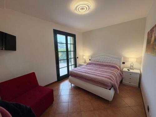 a bedroom with a bed and a red couch at Ami Affittacamere 3 in Castel San Giovanni