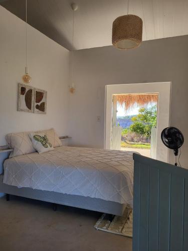 a bedroom with a bed and a window at Casa Vento e Mar in Japaratinga