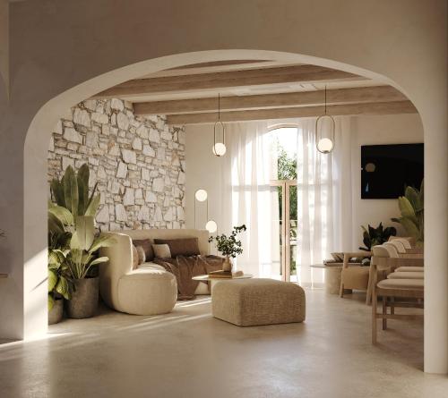 a living room with a couch and a stone wall at Byblos Mare-The Exclusive Beach Front Villa in Skala Sotiros