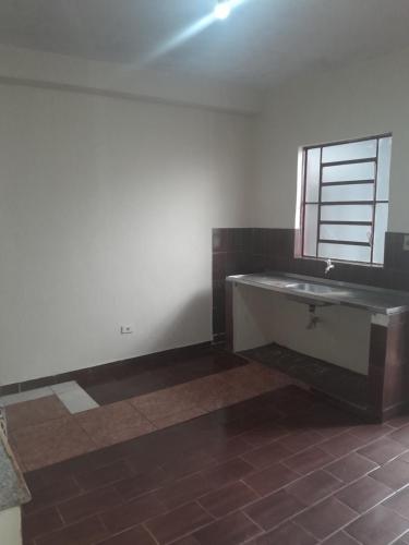 an empty bathroom with a sink and a window at Casa agrishow in Ribeirão Preto