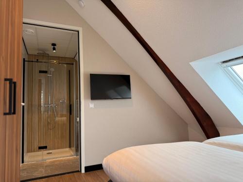 a bedroom with a shower in a attic at Zen Kitchen & Boutique Hotel in Brouwershaven