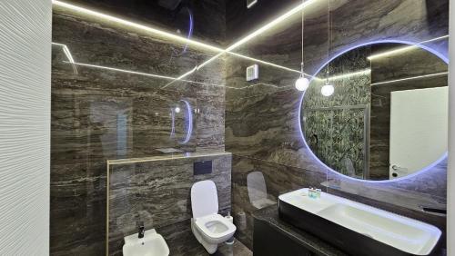 a bathroom with a sink and a toilet and a mirror at NORDIC Residence Apart Hotel in Suceava