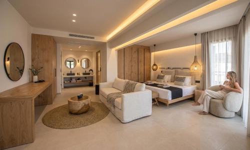 a woman is sitting in a hotel room at Indigo Suites Collection Adults Only in Hersonissos