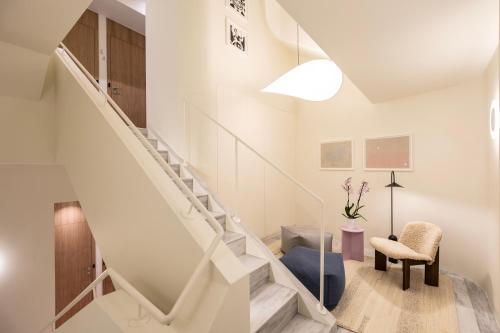 a white staircase in a living room with a chair at Milioni by Oniro in Athens