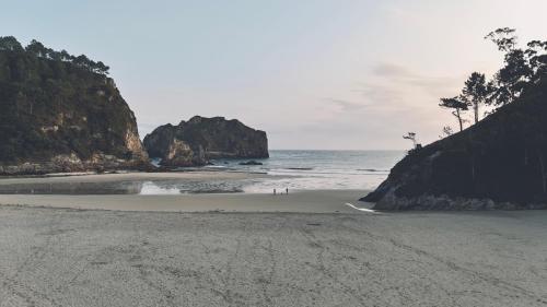 a beach with rocks and the ocean in the background at HolaCamp la Franca in Las Conchas