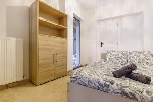 a bedroom with a bed and a wooden cabinet at Cour des Moines - centre ville in Le Blanc