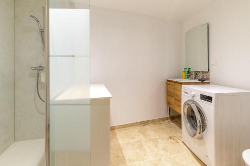 a bathroom with a washing machine and a shower at Cour des Moines - centre ville in Le Blanc