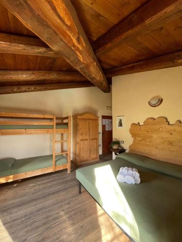 a bedroom with two bunk beds and wooden ceilings at B&B Agriturismo Montepolo in Canavaccio di Urbino