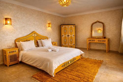 a bedroom with a bed with a teddy bear on it at Dar Laydam in Aït Zat