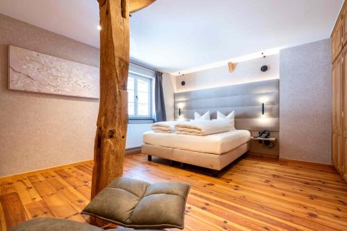 a bedroom with a bed and a chair in a room at Le Vieux Moulin Weywertz in Butgenbach
