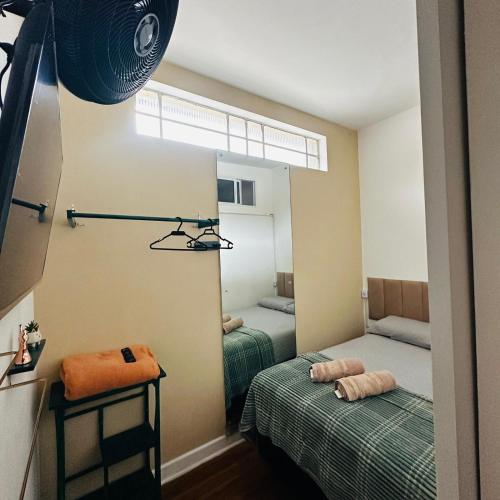 a small room with two beds and a mirror at Pousada Monte Gerizim in São Paulo