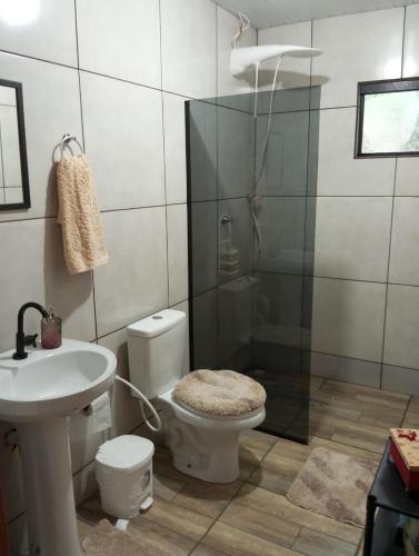 a bathroom with a shower and a toilet and a sink at Cantinho do Sossego in Prudentópolis