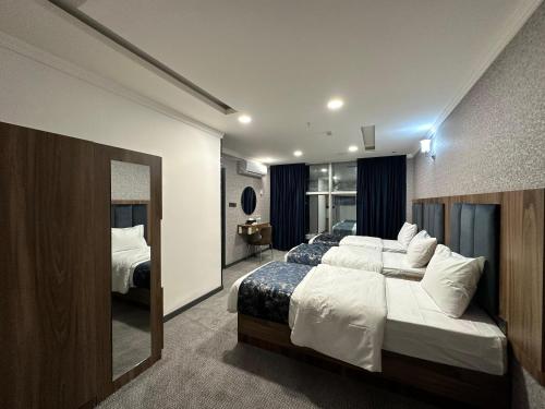 a hotel room with two beds and a mirror at MyFlower 1 Hotel in Erbil