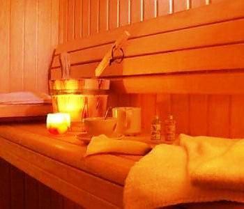 a bed with a wooden headboard with a light on it at Hotel Le Blanche Neige in Valberg