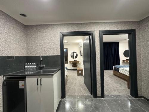 a bathroom with a sink and a room with a bed at MyFlower 1 Hotel in Erbil