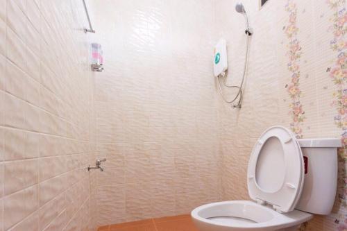 a bathroom with a white toilet and a shower at Benya Hotel โรงแรมเบญญา in Nan