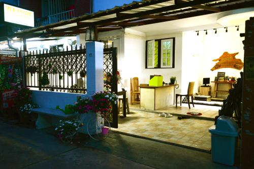 une maison avec une terrasse couverte dotée d'un banc et d'une table dans l'établissement Sindyguesthouse, à Chiang Mai