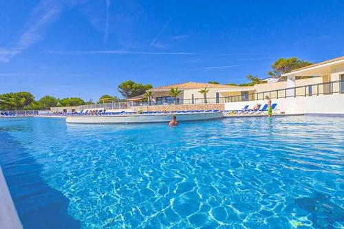 a boat in the water at a resort at Camping l'Arquet - Mobil-home Premium 4 pièces 6 personnes climatisé MAE-3771 in Martigues
