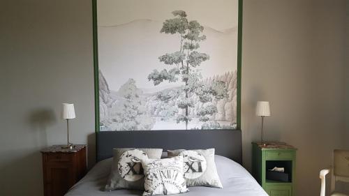 a bedroom with a large painting above a bed at chambres d'hôtes du Tilleul in Nanteuil-en-Vallée