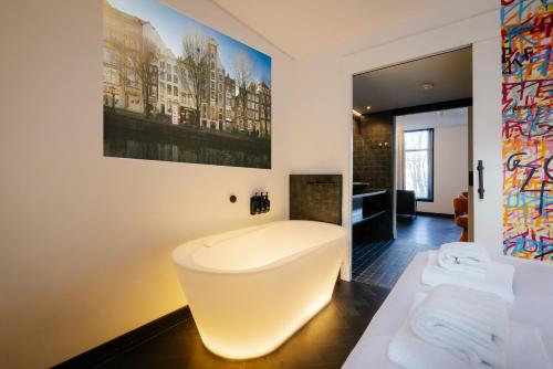 a bathroom with a white tub in a room at Supper Boutique Suites in Amsterdam