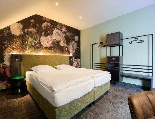 a bedroom with a bed with a flower mural on the wall at Hotel Elsen in Grevenbroich