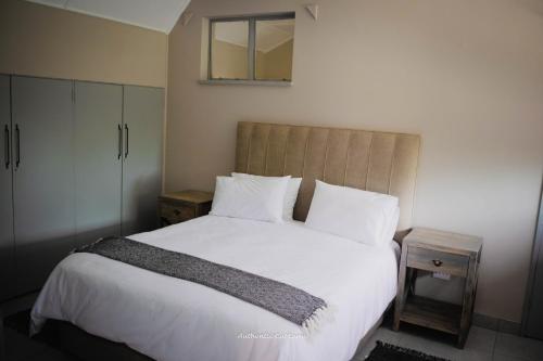 a bedroom with a large bed with white sheets and pillows at The Nelsons on 99 Smith in Dundee