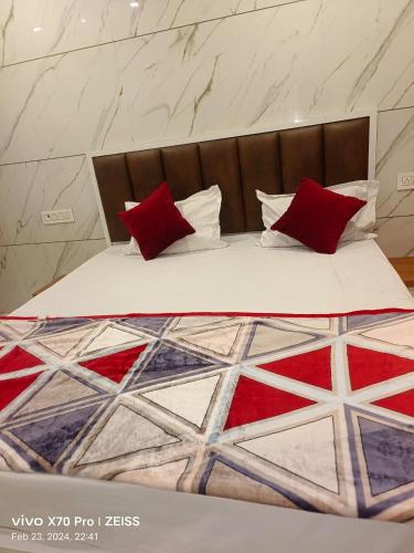 a bed with two red pillows on top of it at HOTEL JANTA INn in Vapi