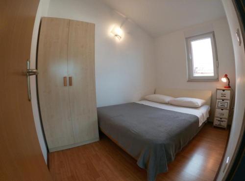 a small bedroom with a bed and a closet at Sanja Apartments Posedarje in Posedarje