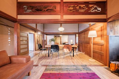 a living room with a table and chairs at 城ヶ島 浦ノ間邸 デザイナーズ古民家サウナヴィラ 富士山ビューBBqテラス付 in Miura