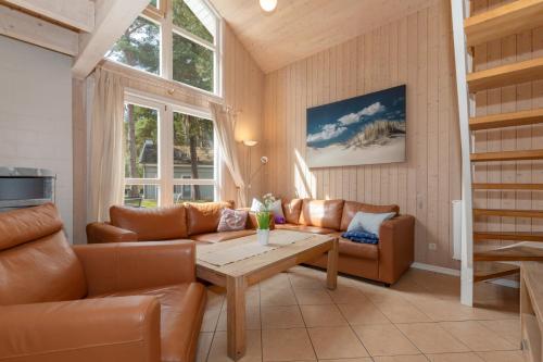a living room with leather furniture and a table at Dünenblume - Baabe in Baabe