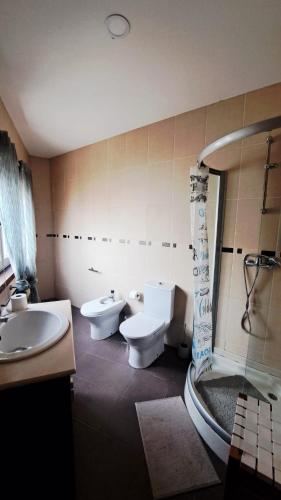 a bathroom with two toilets and a sink and a shower at Casa do Vale in Apúlia