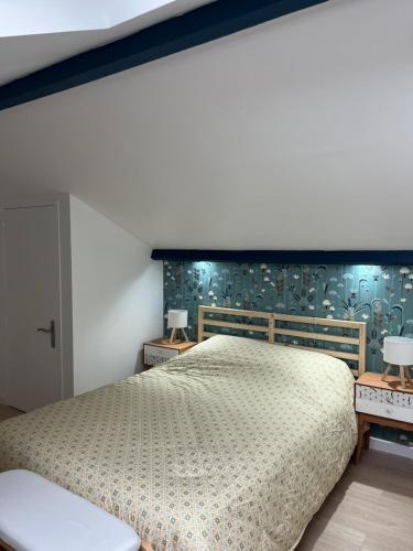 a bedroom with a large bed and two tables at Le cocon des Sacres in Reims