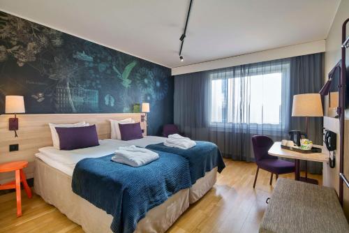 a hotel room with a bed with towels on it at Scandic Södertälje in Södertälje