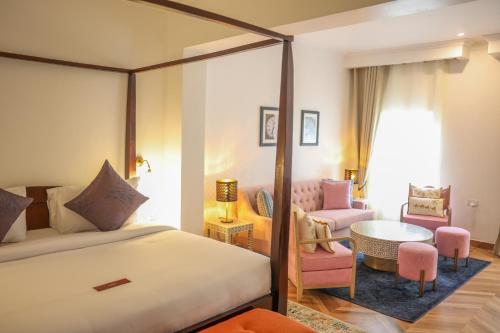 a bedroom with a bed and a table and chairs at Mount Elgon Hotel & Spa in Mbale