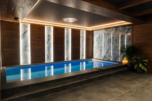 a swimming pool in a room with a large window at Casa Guargnè in Cortina dʼAmpezzo