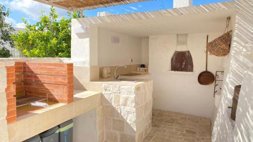 a kitchen with a brick fireplace in a house at Trullo al borgo in Cisternino