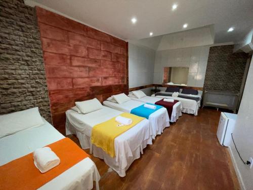 a room with four beds and a brick wall at Pousada Bahia Morena in Salvador