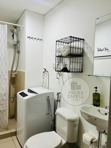 a white bathroom with a toilet and a sink at Deck&Dwell in Trece Martires