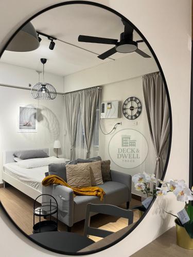 a bedroom with a bed and a chair and a mirror at Deck&Dwell in Trece Martires