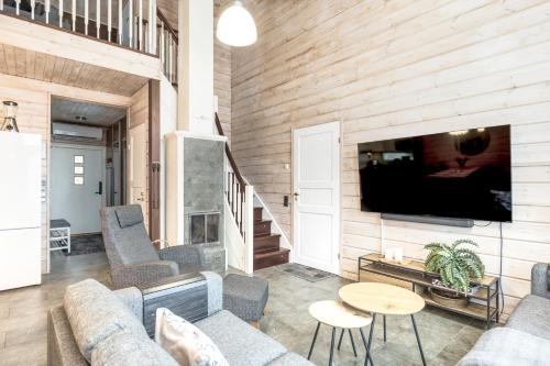 a living room with a couch and a tv at Villa Peso 2 Incl WiFi, AC and Jacuzzi for extra fee in Himos
