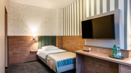 a hotel room with a bed and a flat screen tv at Hotel La Mar in Kielce