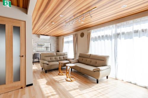 a living room with two chairs and a couch at トキテラス五条 in Dazaifu