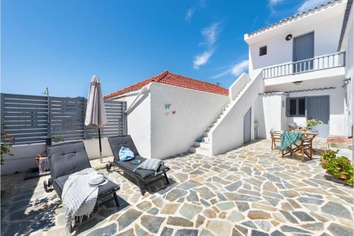 a patio with two chairs and an umbrella at Traditional Dream House in Soroni