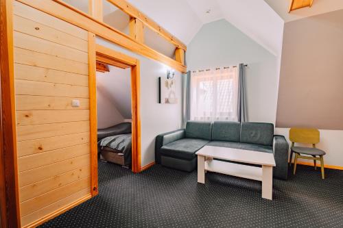 a room with a couch and a table and a bed at Zajazd Fojutowo in Legbąd